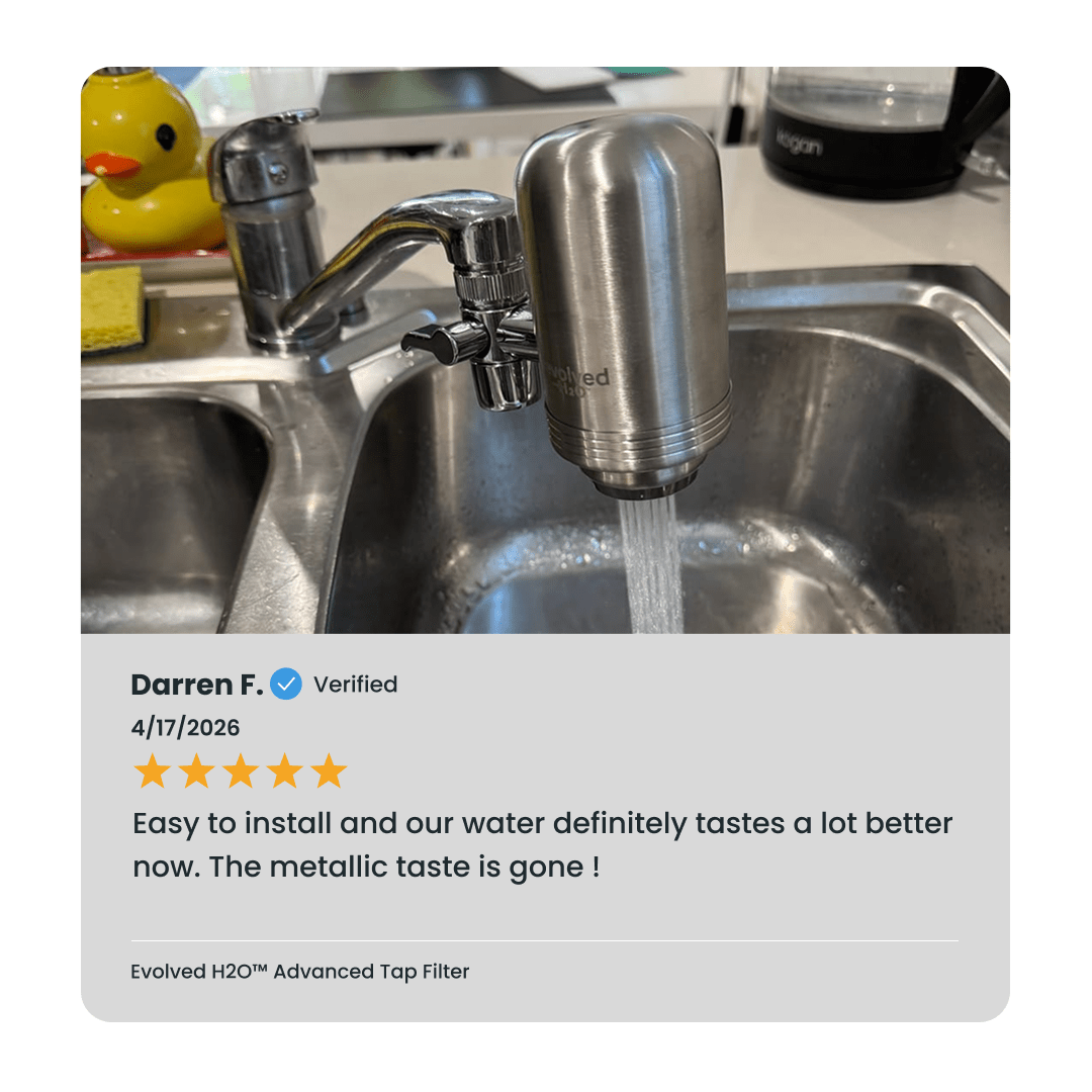 Evolved H2O Advanced Tap Water Filter installed on a kitchen tap with water flowing into the sink and verified customer review