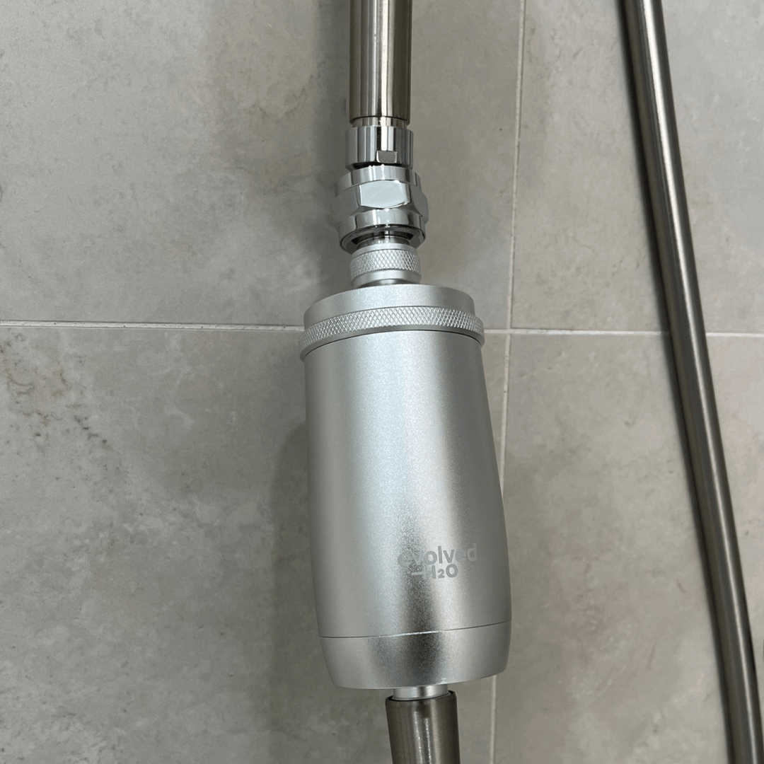 Evolved H2O shower filter installed beneath a shower arm using a swivel ball adapter