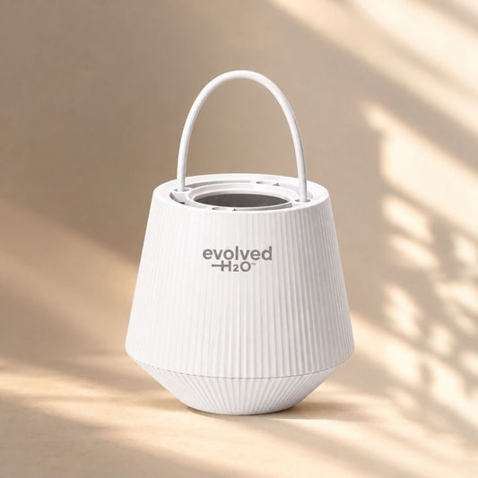 Evolved H2O bath filter in white with carry handle, displayed in warm natural bathroom light
