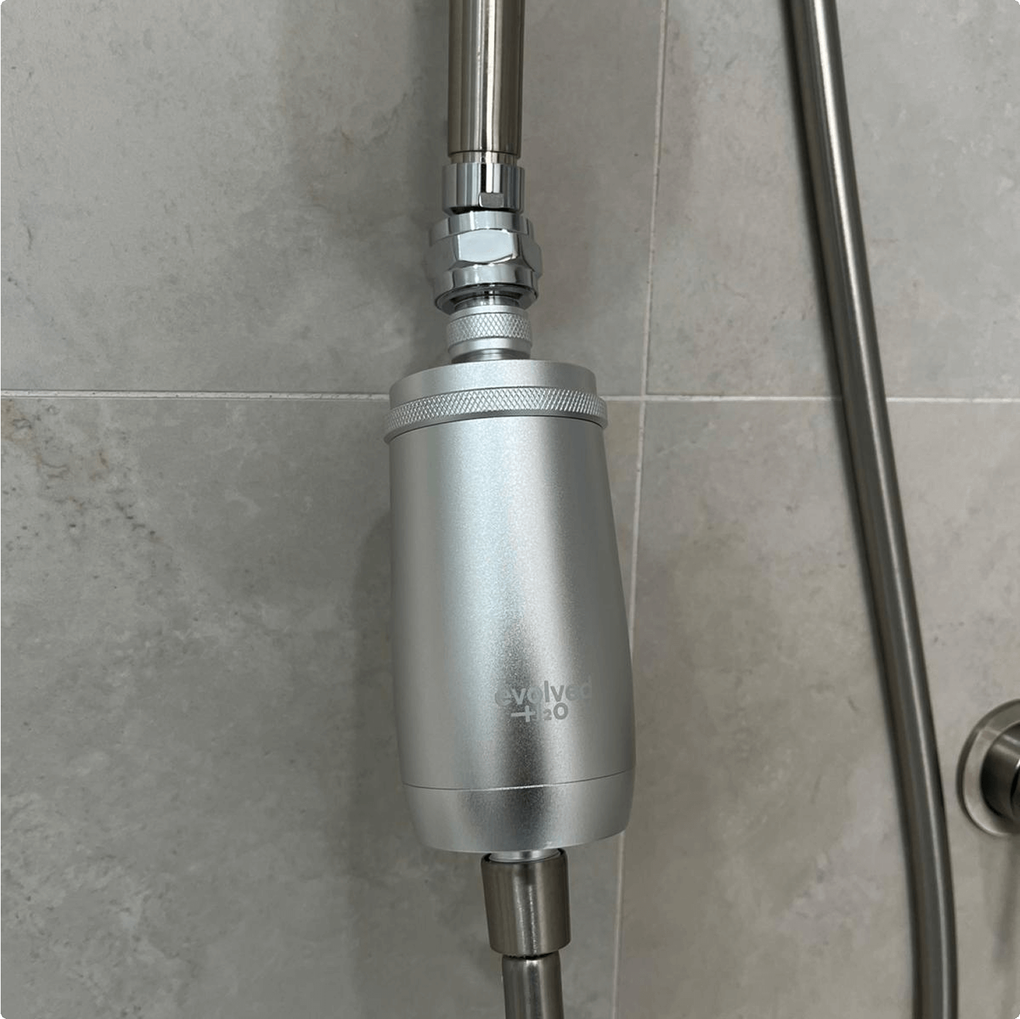 The swivel adapter shown connecting an Evolved H2O shower filter to a shower arm.