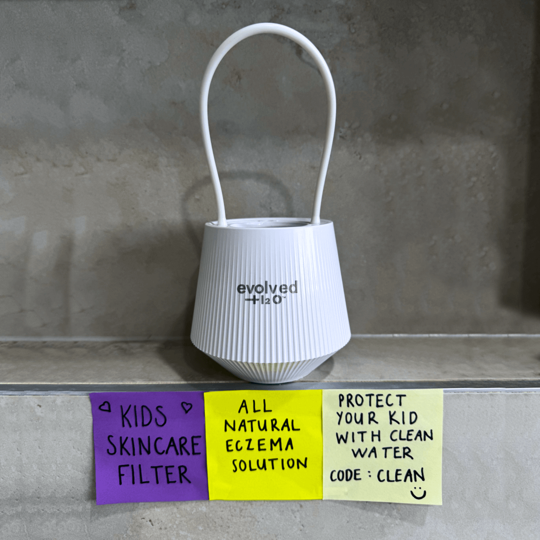 Evolved H2O bath filter on bathroom ledge with handwritten notes about kids skincare and cleaner water.